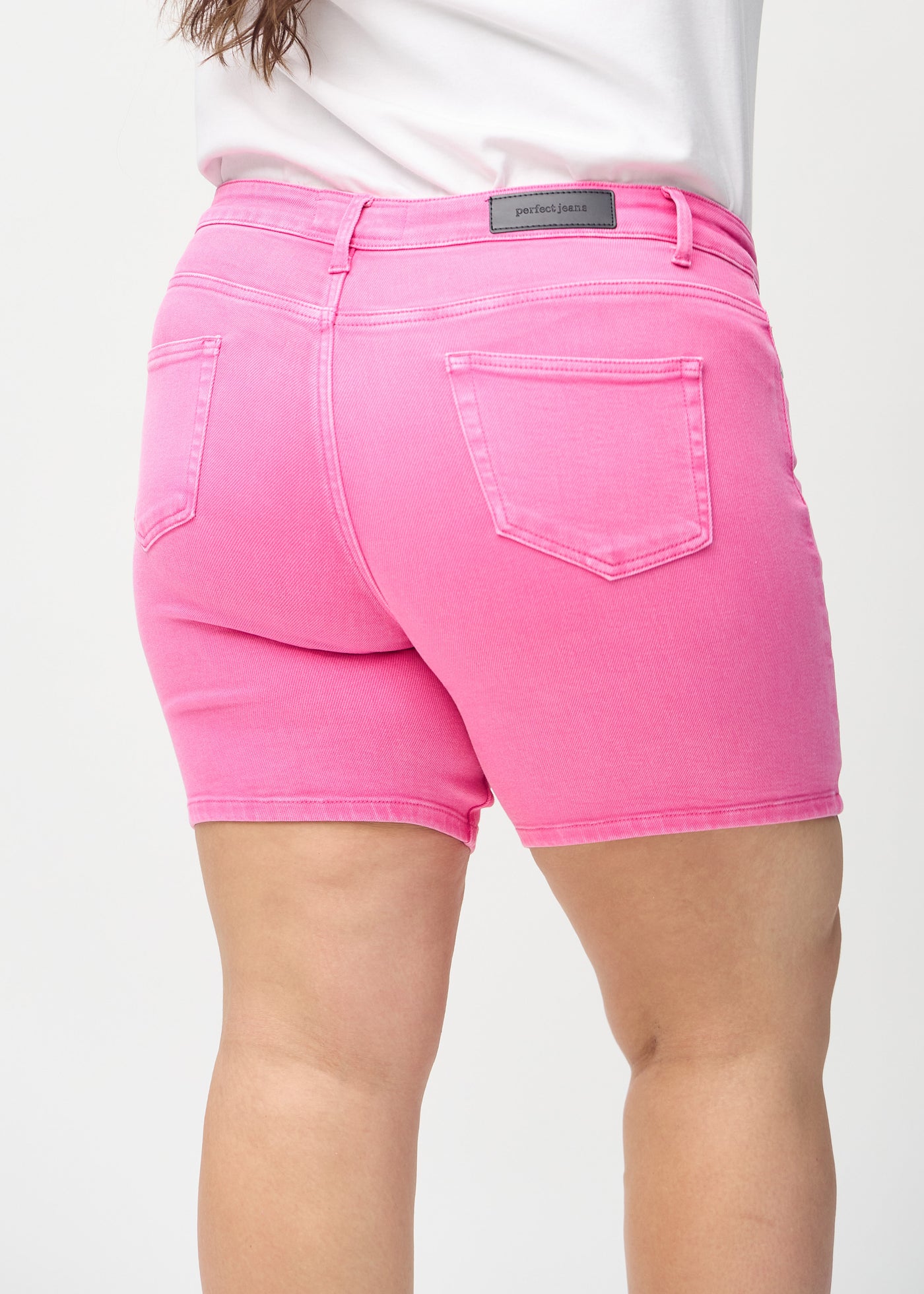 Lyserøde skinny short shorts set bagfra tæt på en plus-size model for at vise detaljer.