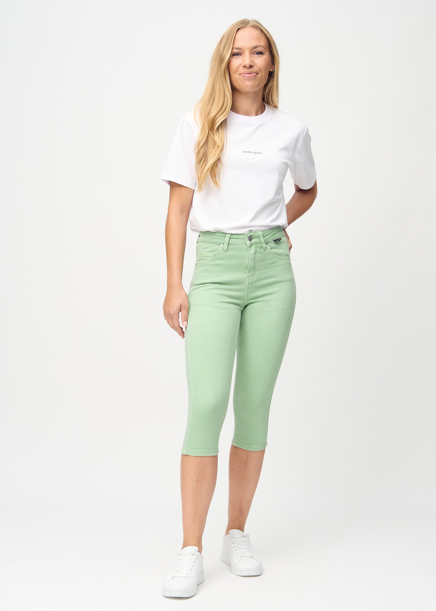 Fuldt billede af model i lysegrønne skinny capris.