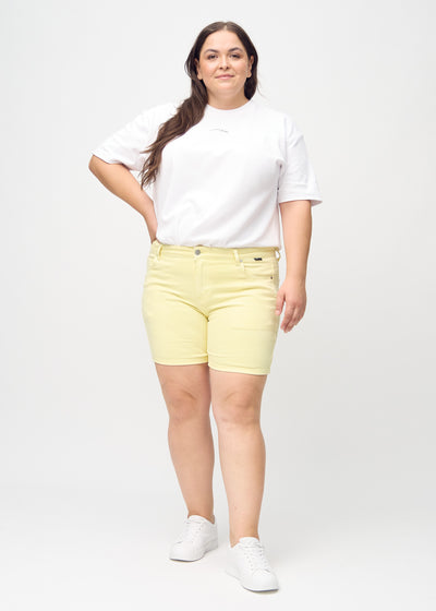 Plus-size model går ind i billedet, strækker i sine shorts, viser dem frem ved at dreje rundt, og forlader derefter billedet.